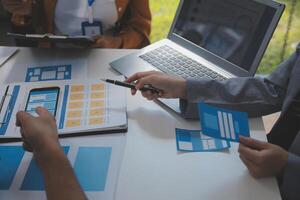 Close up ux developer and ui designer use augmented reality brainstorming about mobile app interface wireframe design on desk at modern office.Creative digital development agency photo