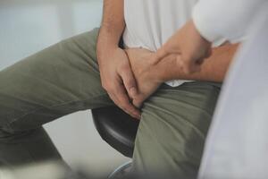 Male diseases. Man presses hands to his groin and suffering from pain, panorama, cropped, studio shot photo