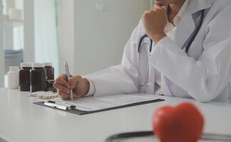 manos de médico mujer participación rojo corazón, demostración símbolo de amar, humano apoyo a paciente, promoviendo médico seguro, temprano chequeo para cuidado de la salud, cardiólogo ayuda. cerca arriba de objeto foto