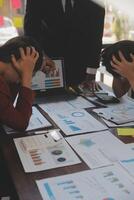 Frustrated upset multiracial business team people sad with bad work result in report disappointed in corporate bankruptcy failure crisis worried of paperwork problem sit at table at office meeting photo