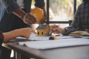 A team of construction engineers talks to managers and construction workers at the construction site. Quality inspection, work plan, home and industrial building design project photo