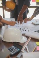 A team of construction engineers talks to managers and construction workers at the construction site. Quality inspection, work plan, home and industrial building design project photo