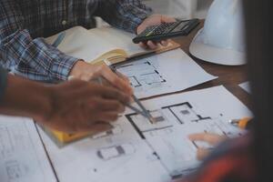 A team of construction engineers talks to managers and construction workers at the construction site. Quality inspection, work plan, home and industrial building design project photo