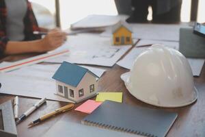 A team of construction engineers talks to managers and construction workers at the construction site. Quality inspection, work plan, home and industrial building design project photo