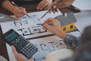 A team of construction engineers talks to managers and construction workers at the construction site. Quality inspection, work plan, home and industrial building design project photo