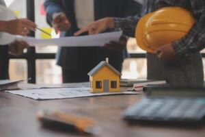 A team of construction engineers talks to managers and construction workers at the construction site. Quality inspection, work plan, home and industrial building design project photo