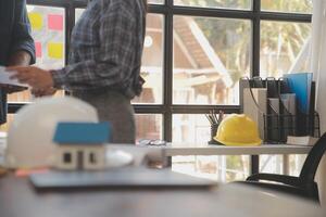 A team of construction engineers talks to managers and construction workers at the construction site. Quality inspection, work plan, home and industrial building design project photo