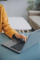 Happy millennial caucasian lady in suit typing on tablet at workplace with laptop in light office interior. Manager work, business with device, app, chat with client remotely photo