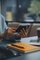 Happy pretty millennial Indian girl relaxing at home, resting in armchair, typing on smartphone, using online app, software, shopping on Internet, making video call. Mobile phone communication photo