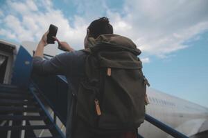 contento atractivo asiático mujer viajero con mochila a el moderno aeropuerto Terminal, Copiar espacio, turista viaje viaje concepto foto