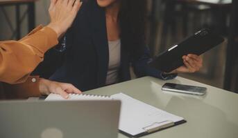 asiático mujer de negocios trabajando en ordenador portátil computadora Mira para trabajo en línea, Lanza libre mirando y mecanografía en cuaderno en mesa, estilo de vida de mujer estudiando en línea foto