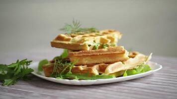 Homemade fried vegetable waffles with herbs inside on a wooden table video