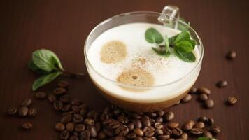 Cup of coffee latte with heart shape and coffee beans on old wooden background video