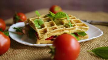 belegd broodje van twee ei omeletten met spek en tomaten binnen, wafel gevormd. video