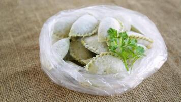 brut vert pâte Dumplings avec persil, aneth. brut Dumplings dans une sac sur toile de jute. video