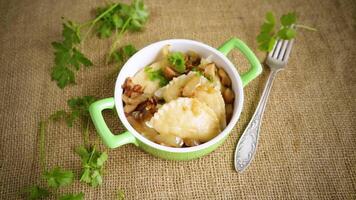 Potato dumplings with onion and mushrooms in a ceramic plate. video