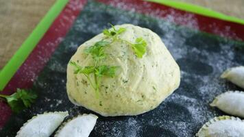 crudo verde masa con perejil, eneldo con crudo albóndigas crudo empanadillas en un de madera mesa. video