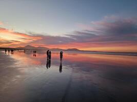 puesta de sol en famara playa en lanzarote isla foto