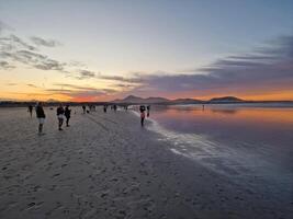 puesta de sol en famara playa en lanzarote isla foto