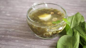 Spring soup from fresh sorrel with boiled eggs in a plate on a wooden table video