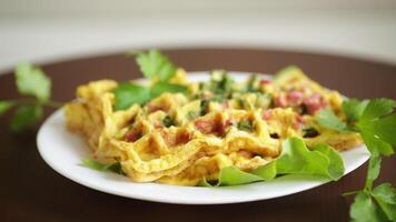 ovo omelete recheado com verduras e linguiça frito dentro a Formato do waffles, em uma de madeira mesa video