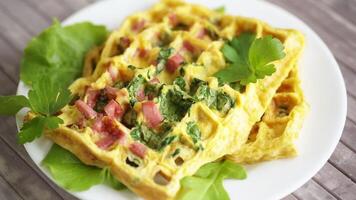 ovo omelete recheado com verduras e linguiça frito dentro a Formato do waffles, em uma de madeira mesa video