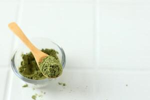 matcha verde té polvo en de madera cuchara foto