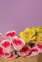 Bouquet of roses in a paper bag on a pink background with copy space for your text. photo