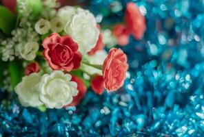 Bouquet of artificial rose flowers on blue background. Close up, photo