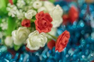 Colorful artificial rose flowers on blue bokeh background. photo