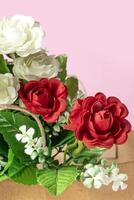 Bouquet of red and white roses in box on pink background. photo