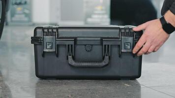 The Mechanic Opens A Large Black Tool Box. Close-up Of A Hand Opening A Box. photo