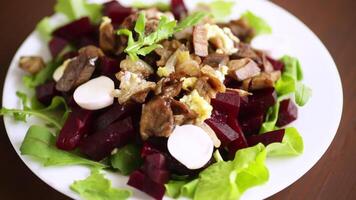 Salad with boiled beets, fried eggplants, herbs and arugula in a plate video