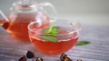 fermentato rosa canina tè nel un' bicchiere teiera con rosa canina fiori e menta video