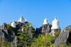 blanco de cielo pagoda en montaña con azul cielo. con verde bosque. antecedentes a wat chaloem phra kia frachomklao rachanusorn lampang tailandia foto