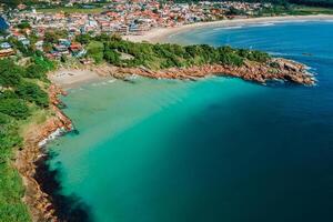 Beach with rocks and ocean in Brazil. Drone view of coastline beach in Florianopolis photo