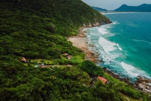 Coastline with beach, mountains and ocean with waves in Brazil. photo