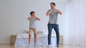 Family fitness at home, Father coach, Sports kid, Fun gymnastics. Dad and son doing physical exercise squatting together while standing on the floor at home video