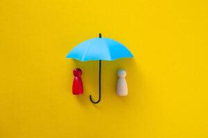 Blue toy umbrella and wooden doll figures. photo