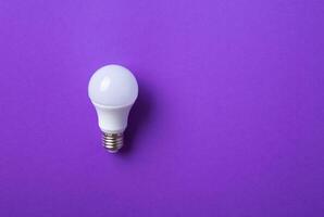 White lightbulb on purple background. photo