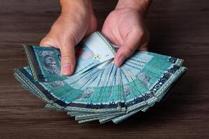 Hand hold each banknote of 50 Ringgit Malaysia. Finance Concept photo