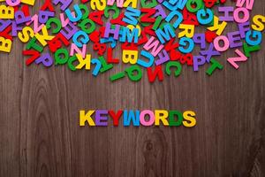 Color letters of the alphabet and the word KEYWORDS on wooden background photo