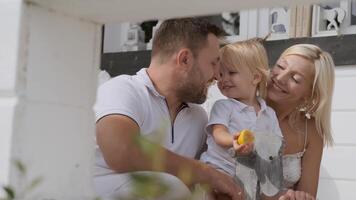 Happy father and mother are playing with their little beautiful son while having a good mood video