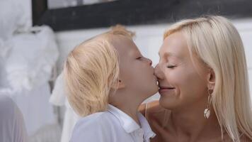 Close-up of a young beautiful blonde mom kisses with her son video