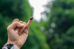 púrpura tinta en mujer dedo después presidencial elección en Indonesia foto