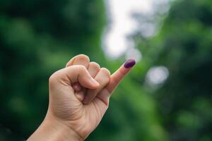 púrpura tinta en mujer dedo después presidencial elección en Indonesia foto