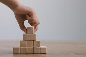 Businesswomen stack blank wooden cubes on the table with copy space, empty wooden cubes for input wording, and an infographic icon photo