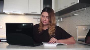 schön jung weiblich mit lange dunkel Haar Arbeiten hinter ein Handy, Mobiltelefon Computer mit ein Tagebuch beim Zuhause Sitzung beim ein Tabelle video