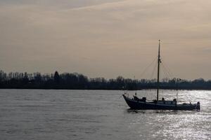 fishing boat on a large river in the evening sun photo