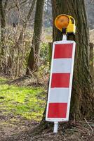 red and white warning sign with warning light photo